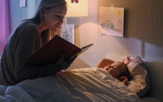 Bedtime Stories: Mother reading a storybook to her daughter before bedtime.- Babyhub