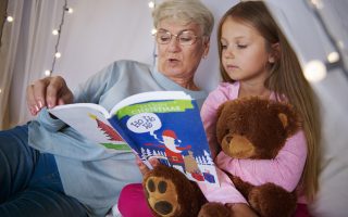 Grandmother reading stories out to her granddaughter- Babyhub